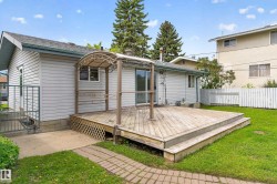 Expansive wood deck with a built-in pergola, offering direct access to the interior via sliding glass doors - 