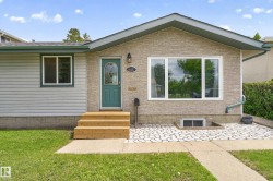 Exterior featuring a teal entry door with decorative glass, new wood steps, a large picture window, and textured stone-look siding - 