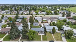 Residential neighborhood featuring established homes, mature trees, and a visible road network - 