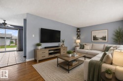 Living area featuring wood-finish flooring, light blue wall tones, and recessed lighting - 