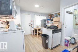 Wood-finish flooring throughout, with a white exterior door and a light-colored wall paint - 