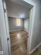 Room featuring wood-finish flooring, light gray walls, a recessed ceiling light, and a window with blinds - 