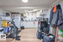 Kitchenette featuring white cabinetry, light-toned wood-finish flooring, a white subway tile backsplash, a black electric range, and a black faucet - 