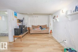 Open-concept room featuring wood-finish flooring, white painted walls, and ceiling-mounted light fixtures - 