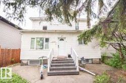 Two-story property with white siding, featuring a front entry with steps and white railings - 