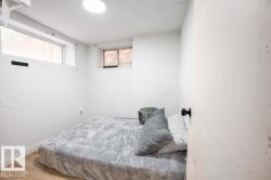 White interior room featuring wood-finish flooring, two windows, and an overhead circular light fixture - 