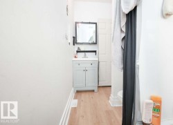 Bathroom featuring a light-colored vanity with a white countertop and a rectangular mirror with a dark frame - 
