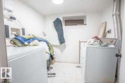 Utility room featuring a window opening, overhead lighting, and white walls - 