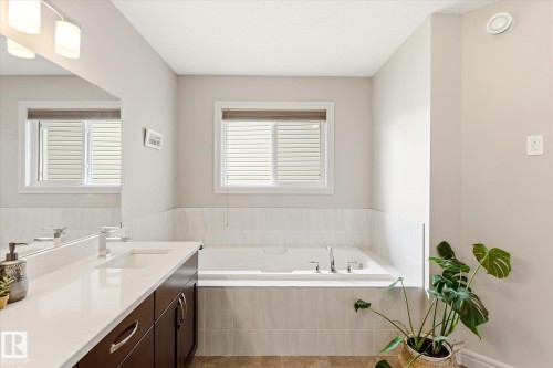 Spa-like bathroom with a built-in soaking tub featuring chrome fixtures and a tiled surround - 3685 Westcliff Way, Edmonton, AB 