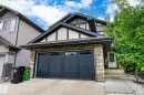 Exterior featuring stone veneer accents, multi-pane garage door, and a covered entry - 3685 Westcliff Way, Edmonton, AB 