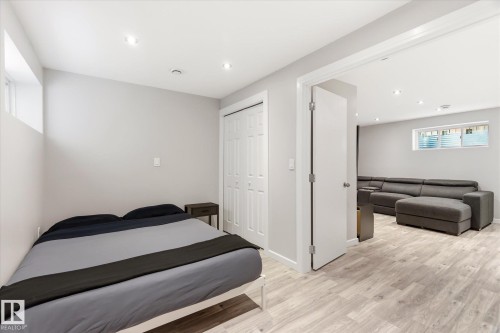 Light-filled bedroom featuring wood-finish flooring, recessed lighting, and a bi-fold closet - 3685 Westcliff Way, Edmonton, AB 