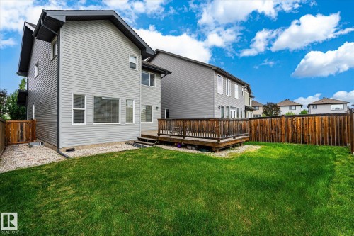 Expansive backyard featuring a manicured lawn, a large wooden deck with railing, and a tall privacy fence - 3685 Westcliff Way, Edmonton, AB 