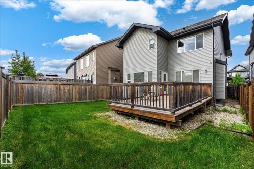 Private fenced backyard featuring a wooden deck, expansive lawn, and gravel landscaping - 3685 Westcliff Way, Edmonton, AB 