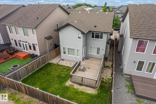 Rear exterior featuring a large wooden deck, expansive green lawn, and a privacy fence - 3685 Westcliff Way, Edmonton, AB 