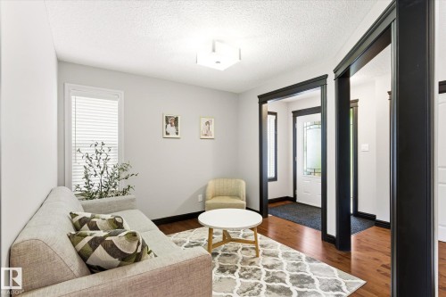Entryway featuring rich wood-finish flooring, white walls, and prominent black trim details - 3685 Westcliff Way, Edmonton, AB 