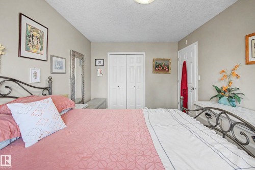 Bedroom featuring neutral wall paint, white bi-fold closet doors, and a white ceiling - 21 1850 Mill Woods Road E, Edmonton, AB 