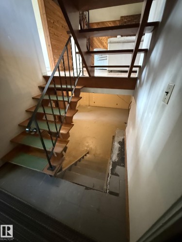 Open-tread staircase with wood-finish steps and wrought iron railing - 16321 - 109A Ave, Edmonton, AB - Indoor Photo Showing Other Room