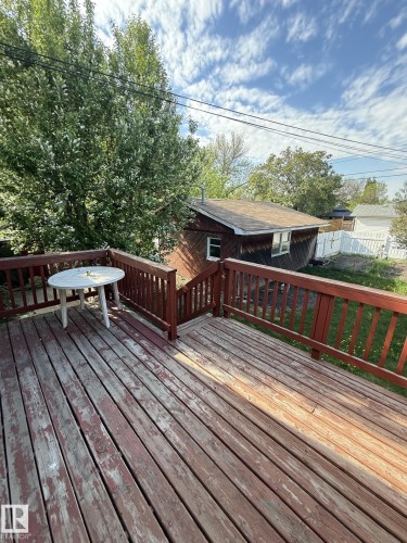 Expansive wood deck featuring a red-stained railing, offering outdoor living space - 16321 - 109A Ave, Edmonton, AB - Outdoor