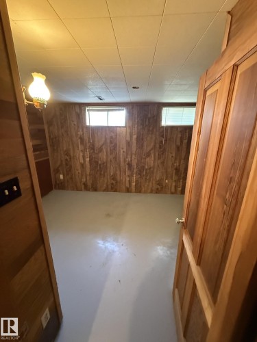 Finished room with wood-paneled walls and a light-colored floor - 16321 - 109A Ave, Edmonton, AB - Indoor Photo Showing Basement
