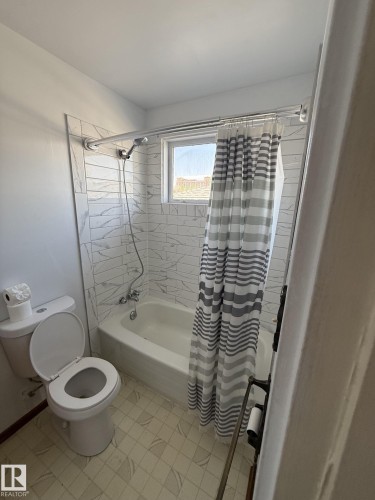 Bathroom featuring a full tub/shower combination with white subway-style tile surround and a window - 16321 - 109A Ave, Edmonton, AB - Indoor Photo Showing Bathroom