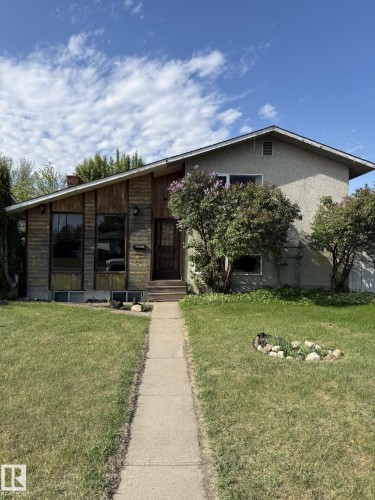 Residential exterior with a split-level design, featuring a wood-paneled facade, stucco siding, and a sloped roofline - 16321 - 109A Ave, Edmonton, AB - Outdoor
