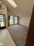 Vaulted ceiling living area featuring a skylight, two large windows, a patterned vinyl entry, and a brass-tone chandelier - 16321 - 109A Ave, Edmonton, AB  - Indoor Photo Showing Other Room 