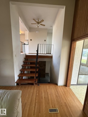 Wood-finish flooring throughout the main level - 16321 - 109A Ave, Edmonton, AB - Indoor Photo Showing Other Room