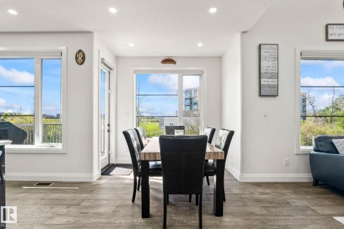 Dining area featuring wood-finish flooring, recessed lighting, and a glass-paneled door - 23 Elwyck Gate, Spruce Grove, AB 