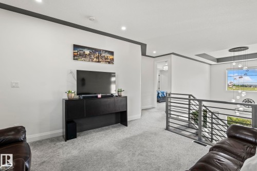 Upper-level landing featuring a contemporary horizontal bar railing, recessed lighting, and a tray ceiling with accent lighting - 23 Elwyck Gate, Spruce Grove, AB 