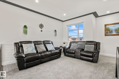 Bright room featuring light grey carpeting and a contrasting dark grey soffit and crown molding - 23 Elwyck Gate, Spruce Grove, AB 