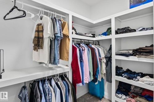 Custom closet system featuring multiple hanging rods, corner shelving, and integrated built-in storage - 23 Elwyck Gate, Spruce Grove, AB 
