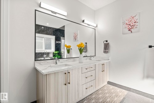 Dual vanity with light wood-finish cabinetry, white countertop, and undermount sinks - 23 Elwyck Gate, Spruce Grove, AB 