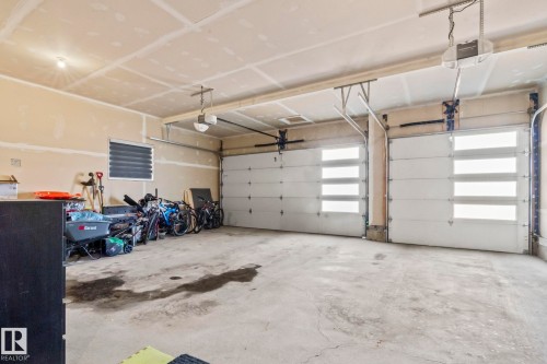 Two overhead garage doors with frosted glass panels and automatic openers - 23 Elwyck Gate, Spruce Grove, AB 