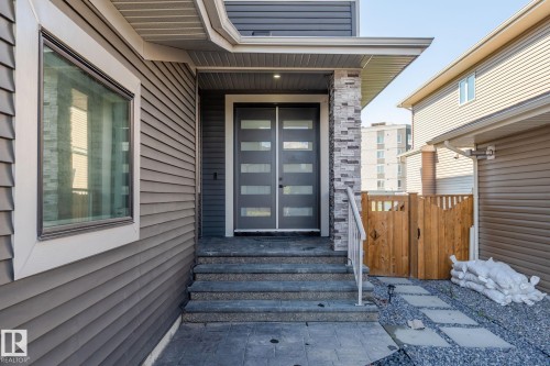 Contemporary exterior featuring horizontal siding and stacked stone accents - 23 Elwyck Gate, Spruce Grove, AB 