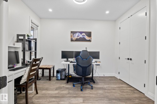 Spacious room featuring wood-finish flooring, white walls, and a window with blinds - 23 Elwyck Gate, Spruce Grove, AB 