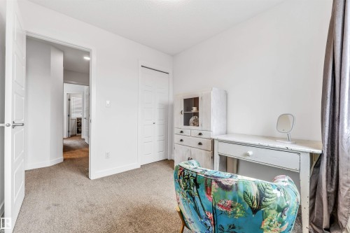 Carpeted room with white walls, a white paneled door, and a white bi-fold closet door - 116 3305 Orchards Link Sw, Edmonton, AB 
