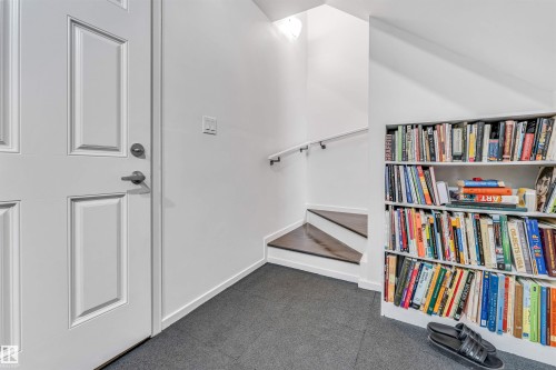 Interior entryway with a paneled white door and dark gray carpet flooring - 116 3305 Orchards Link Sw, Edmonton, AB 