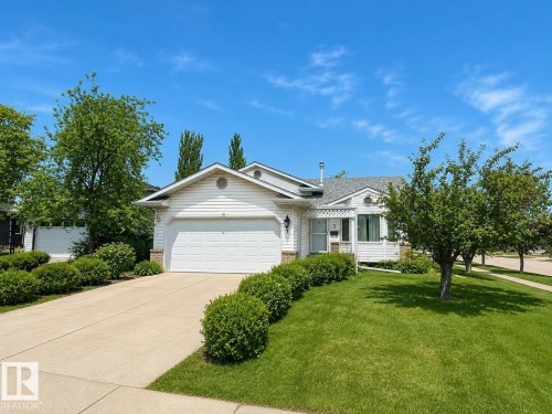 Siding exterior with an attached two-car garage, concrete driveway, and front lawn - 1 Munro Court, Leduc, AB 