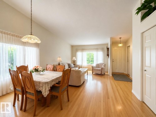 Dining area featuring a vaulted ceiling and wood-finish flooring - 1 Munro Court, Leduc, AB 