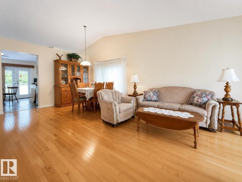 Open-concept living area with light wood-finish flooring - 1 Munro Court, Leduc, AB 