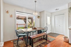 Dining area featuring wood-finish flooring, a large window, and a crystal chandelier - 