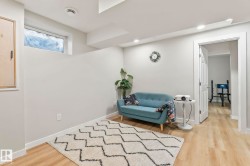 Recessed lighting illuminates this room featuring light wood-finish flooring and a white trim - 