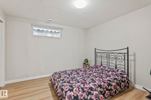 Neutral wall tones, wood-finish flooring, a white trim baseboard, and a high-set horizontal window - 220 85St, Edmonton, AB 