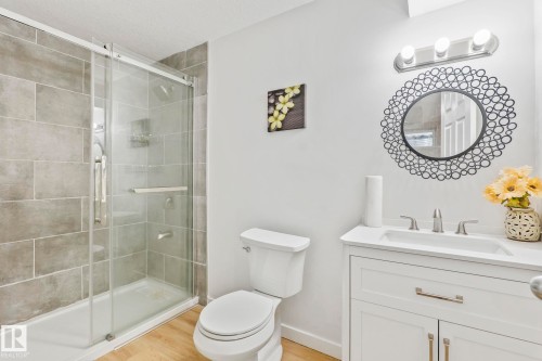Shower with sliding glass enclosure and textured tile surround - 220 85St, Edmonton, AB 