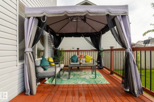 Spacious outdoor deck featuring a gazebo, wood deck flooring, and a railing with dark balusters - 220 85St, Edmonton, AB 