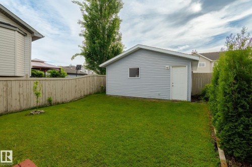 Detached garage featuring light blue siding and a white entry door - 220 85St, Edmonton, AB 