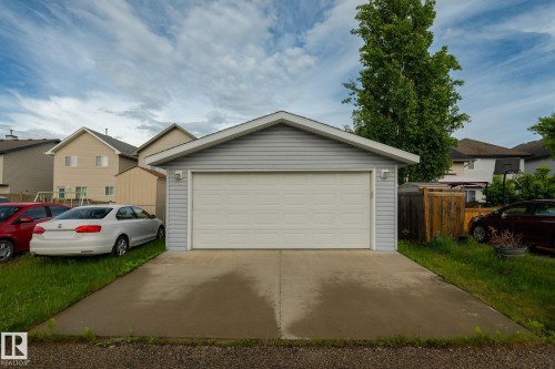 Detached garage with light grey siding and a white panel garage door - 220 85St, Edmonton, AB 