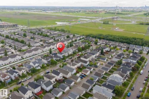 Aerial perspective of a residential neighborhood with a variety of housing styles, featuring a prominent green space - 220 85St, Edmonton, AB 
