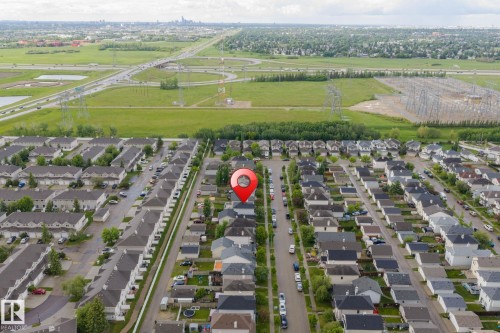 Aerial perspective of a residential neighborhood with a variety of single-family homes and townhomes, featuring dark shingle roofs and light-colored siding - 220 85St, Edmonton, AB 