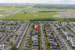 Aerial perspective of a residential neighborhood with a variety of single-family homes and townhomes, featuring dark shingle roofs and light-colored siding - 